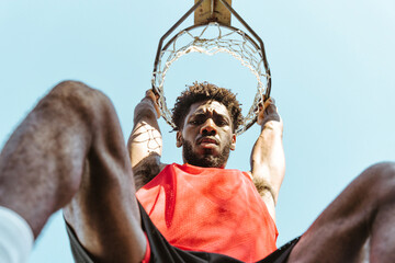 One vs one basketball game training at the court. Cinematic look image of friends practicing shots and slam dunks in an urban area - obrazy, fototapety, plakaty