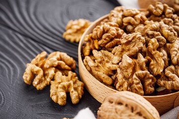 dried walnuts on a black rustic wooden background