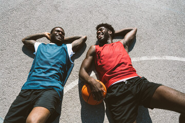 One vs one basketball game training at the court. Cinematic look image of friends practicing shots and slam dunks in an urban area © oneinchpunch