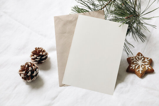 Christmas Still Life. Empty Greeting Card, Invitation Mockup. Gingerbread Cookie, Pine Cones And Pine Tree Branches On White Linen Tablecloth In Sunlight. Gift Wrapping Concept. Winter Festive Flatlay