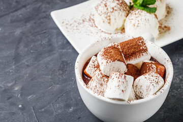 hot chocolate with marshmallows and ice cream balls on a black background
