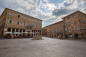 Fototapeta na wymiar Urbino, Marche, Italy - July 2021: central historical square with medieval buildings and open air cafe in the city of Urbino, Marche, Italy.
