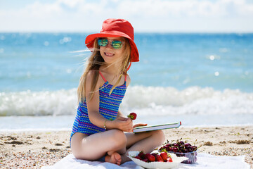 Girl eat berries at summer sea beach