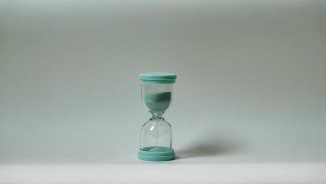 Hourglass on white background. Sand is pouring from one part to another. Time and transience concept.