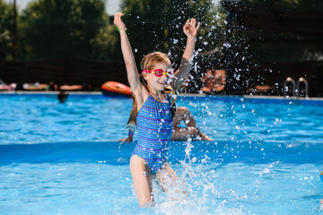 Little girl play with water in pool