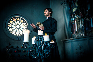 Obraz na płótnie Canvas Priest reading and praying in the church