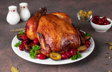 Grilled chicken on Thanksgiving day with plum, dogwood and parsley on brown background