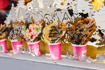 Delicious traditional waffles with whipped cream on display in a store window. Typical Belgian sweet food.