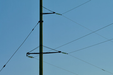 Concrete support for high-voltage wires, horizontal crossbars with wires on a clear sky background, abstract geometric lines, still life of their electrical equipment