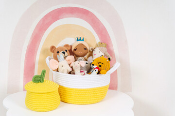 Toys and rag dolls in cloth stylish baskets on the table. Toy Storage Baskets  in the children's...