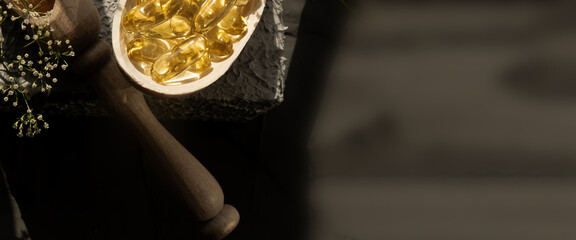 Wooden utensils on the table, spoons, forks, scoops for food, omega 3 vitamins lie in a wooden...