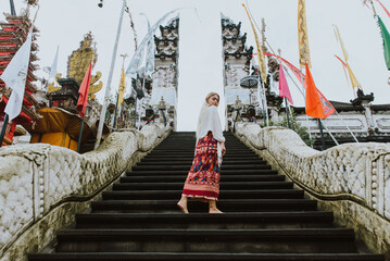 Beautiful caucasian girl visiting the water palace and heaven's door temple in Bali 