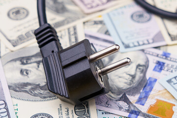 Electric cord plug and dollars on a blurred background, selective focus. The concept of the energy crisis