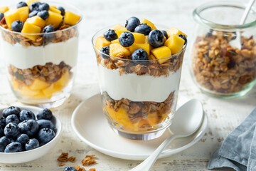 Healthy breakfast, fresh greek yogurt, granola, mango and blueberries