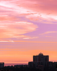 A picture of a sky scraper and a beautiful red and purple sky during the dusk 