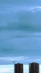 A picture of few buildings under construction and the wide blue sky above it showing the vastness of the universe over any man made buildings