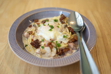 selective focus of spaghetti carbonara with egg.