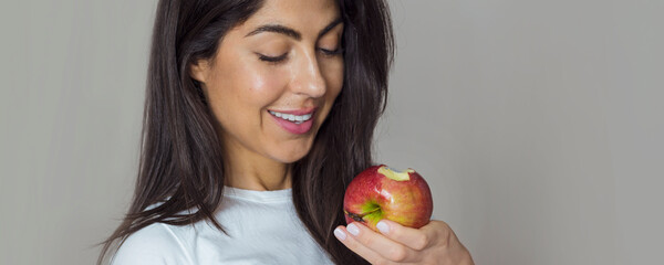 Beautiful Young Woman Holding Red Apple. Healthy Eating and Dental Care Concept . Selective focus 