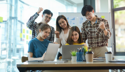 Overjoyed young business people celebrating success startup project together at office meeting..