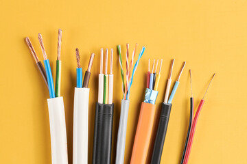 Electric cables, many copper wires with colored isolation isolated on yellow background