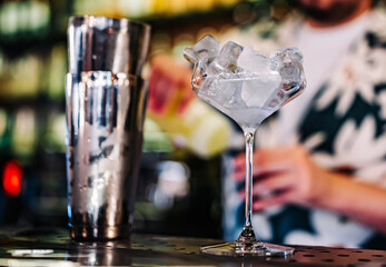 Ice cube in an empty glass on a bar counter in bar or pub