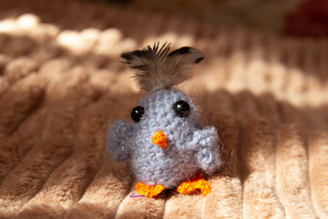 knitted plush bird on a fluffy background 