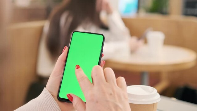 Use green screen for copy space closeup. Chroma key mock-up on smartphone in hand. Woman holds mobile phone