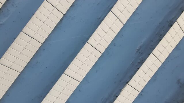 Aerial view of sustainable electrical power plant with solar photovoltaic panels covered with snow in winter for producing clean energy. Concept of low effectivity of renewable electricity in north