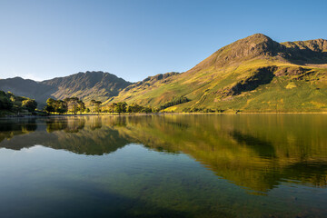 Lake District mountains reflecting in calm water at Buttermere.