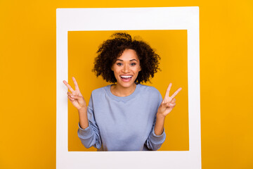Portrait of attractive funky person toothy smile hands fingers demonstrate v-sign isolated on yellow color background