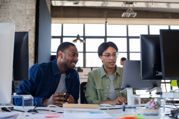 Coworkers working together at a desktop computer
