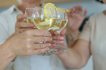 Clinking glasses with white wine and toasting.
