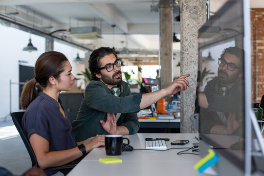 Coworkers looking at a desktop computer together