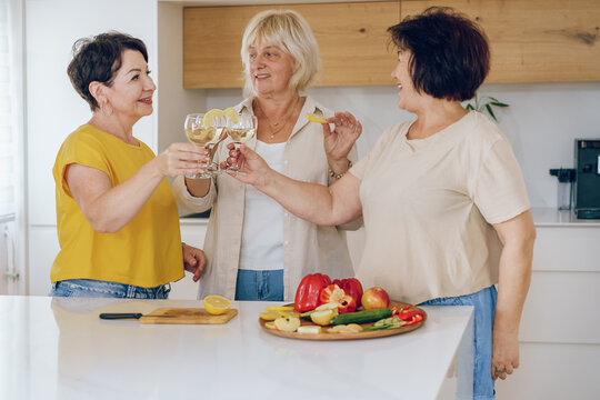 Cheers. Group Of Beautiful Middle Age Women Enjoying A Celebratory Toast Together In A Home.