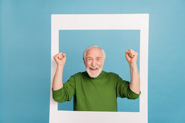Photo of overjoyed delighted funky granddad raise fists celebrate success luck isolated on blue color background - obrazy, fototapety, plakaty