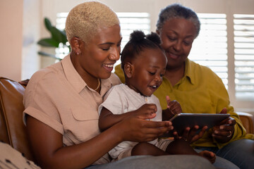 African American family watching entertainment on digital tablet at home