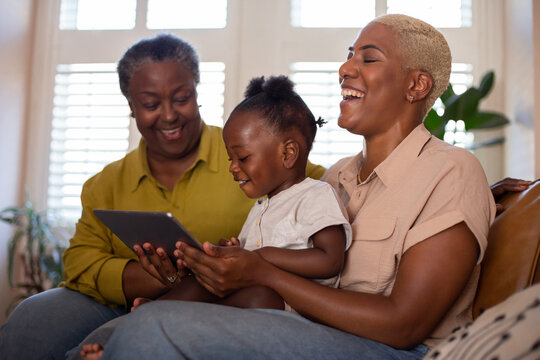 African American family watching entertainment on digital tablet at home
