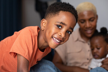 Portrait of African American boy with Mother and sister in the background