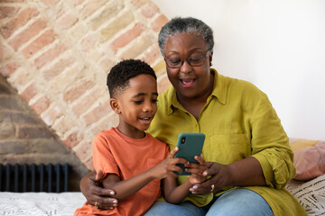 Grandson showing Grandmother how to use a smartphone