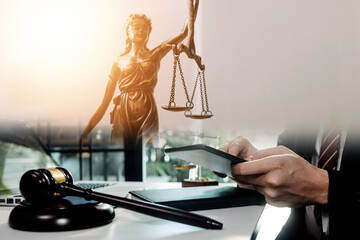 Justice and law concept.Male judge in a courtroom with the gavel, working with, computer and docking keyboard, eyeglasses, on table in morning light