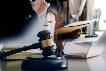 Justice and law concept.Male judge in a courtroom with the gavel, working with, computer and...