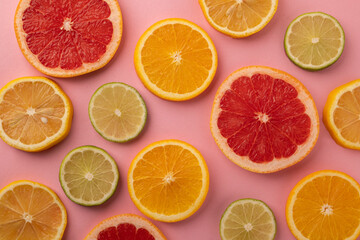 Slices of tropical fruits on a pink background. Top view.