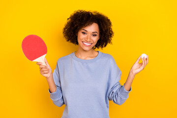 Portrait of positive pretty person hold ping pong racket ball toothy smile isolated on yellow color...