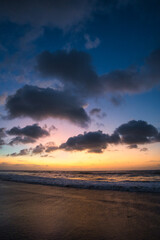 Fototapeta na wymiar Beautiful sunset sunrise at the beach with dramatic clouds in the blue purple yellow sky over the sea - Bali
