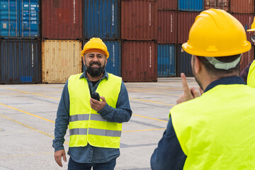 Workers wearing reflective waistcoats and hard hats talking to each other and using a walkie talkie