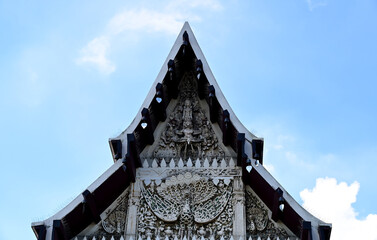 Naklejka premium BANGKOK, THAILAND - September 26, 2022 : Part of the Roof of a temple in Thailand. Traditional Thai style pattern on the roof of a temple with Blue Sky Background.