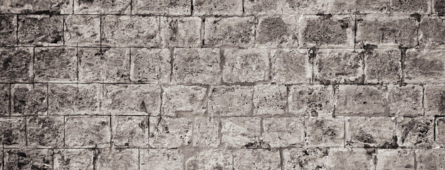 Wide Stone Wall Weathered Obsolete Monotone Texture. Aged Brickwork. Distressed grunge Surface. Background Backdrop Panoramic Banner. Black and white