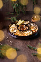 Assorted cheese plate with honey on rustic wooden background. Top view