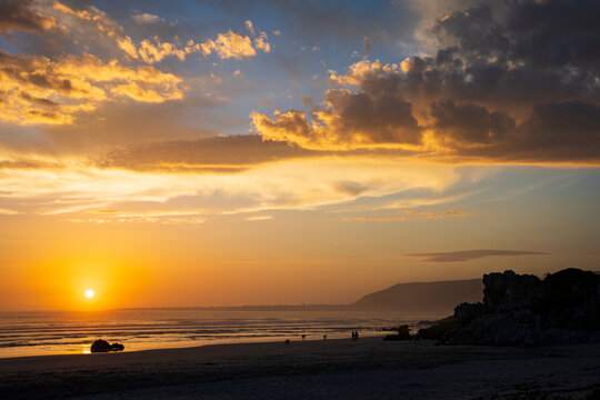 Sunset lighting up the clouds at Grotto Beach at Hermanus, Whale Coast, Overberg, Western Cape, South Africa.