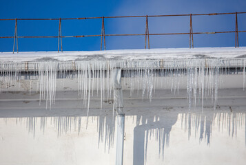 Icicles hang from the roof of the house.